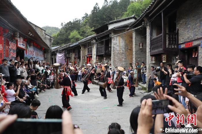 4月12日,在广西金秀瑶族自治县金秀镇六段村,瑶族民众表演黄泥鼓舞吸引游客观看。 张友豪 摄