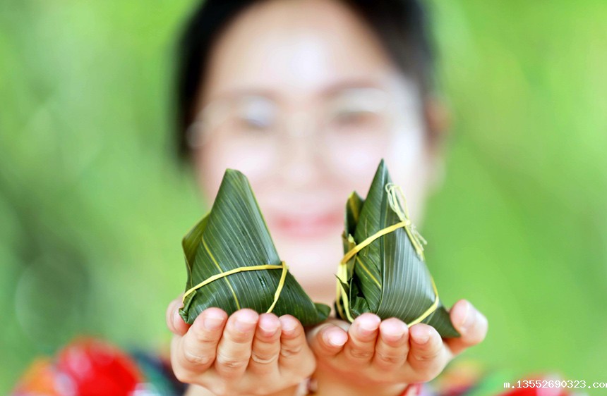 壮族姑娘展示包好的五彩粽子。