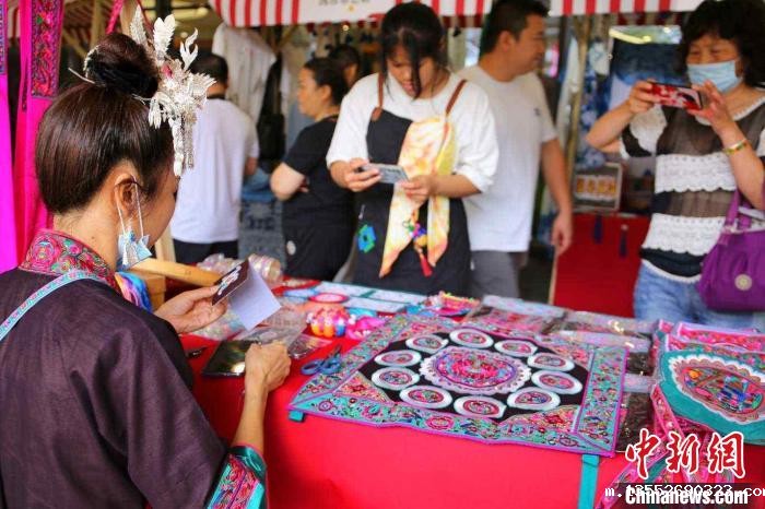 非遗集市中,市民围观侗族刺绣。 蒙鸣明 摄