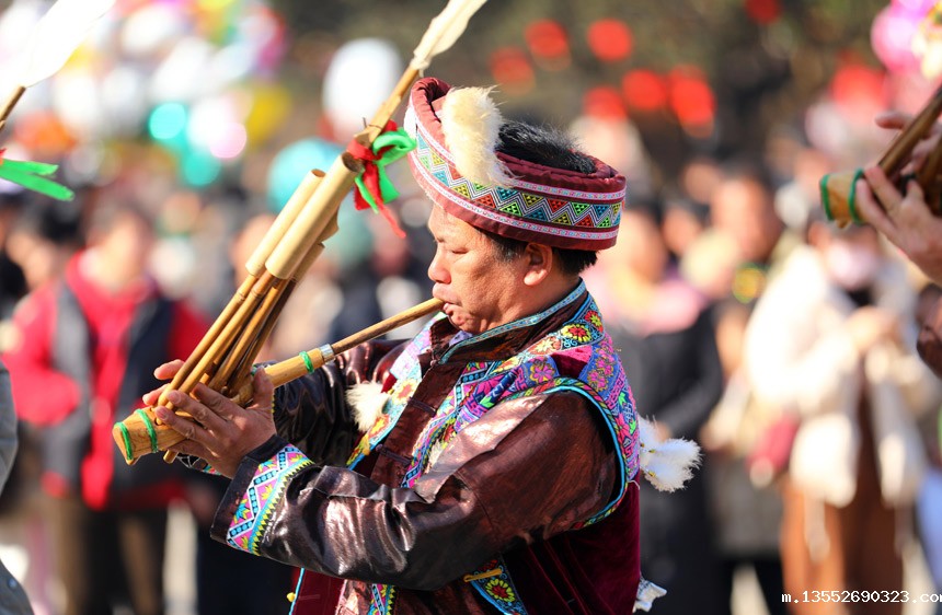 韦苗家汉子正在吹奏芦笙。