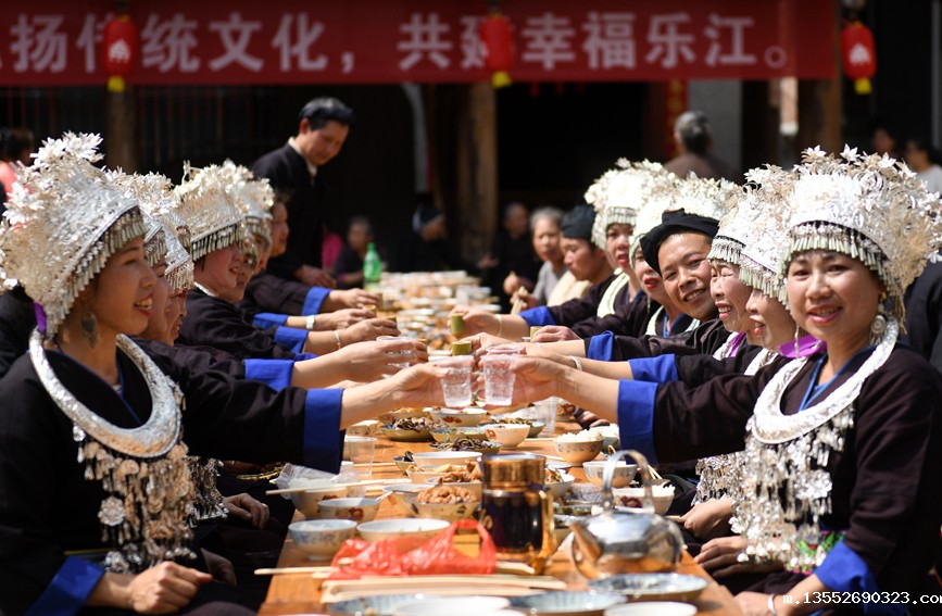 侗族群众与游客在共享合拢宴。潘志祥摄