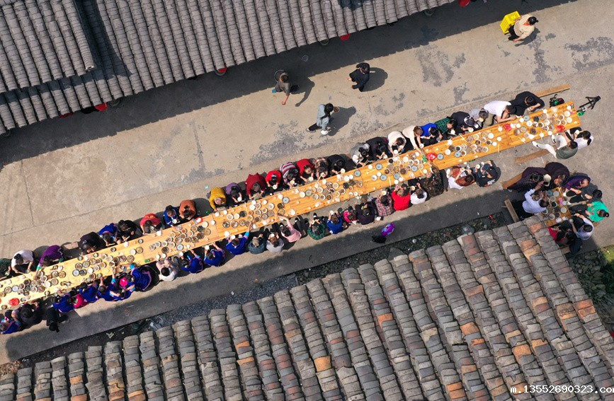 侗族群众与游客在共享合拢宴。潘志祥摄